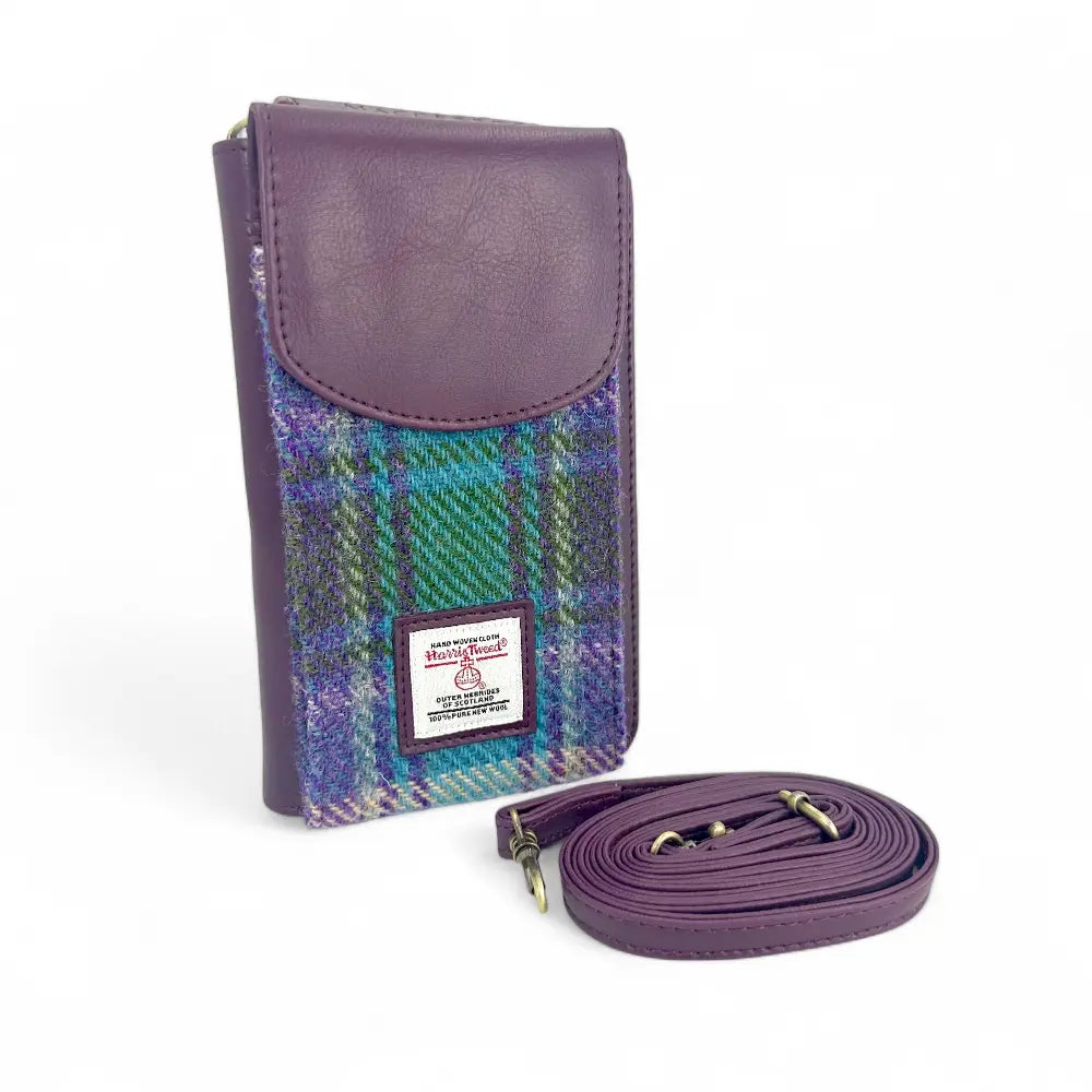 Purple leather and plaid fabric phone pouch with a detachable strap and a front flap closure.